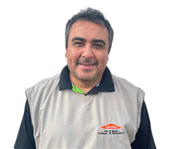 Man with dark hair wearing a SERVPRO vest against white backdrop